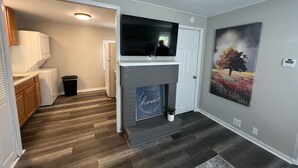 A modern kitchen with built-in appliances, a fireplace, and a mounted TV. - COZY COTTAGE NEAR CEDAR POINT/ KALAHARI /SUMMIT RACEWAY (Norwalk)