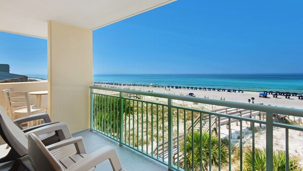Ein Balkon mit Blick auf Strand und Meer.