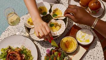 Una mesa dispuesta con diversos platos, incluyendo mariscos, ensaladas y pan, evocando un ambiente para comer.