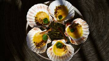 A plate of scallops with a garnish, arranged on a patterned surface.