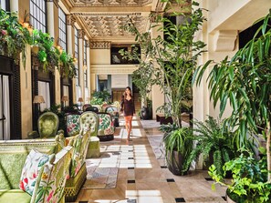 Un vaste espace intérieur doté d’un haut plafond, de décorations élaborées et de différents types de sièges.