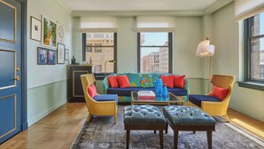 A living room with a sofa, two chairs, a coffee table, and a rug. - Hotel Per La, Autograph Collection (Los Angeles)