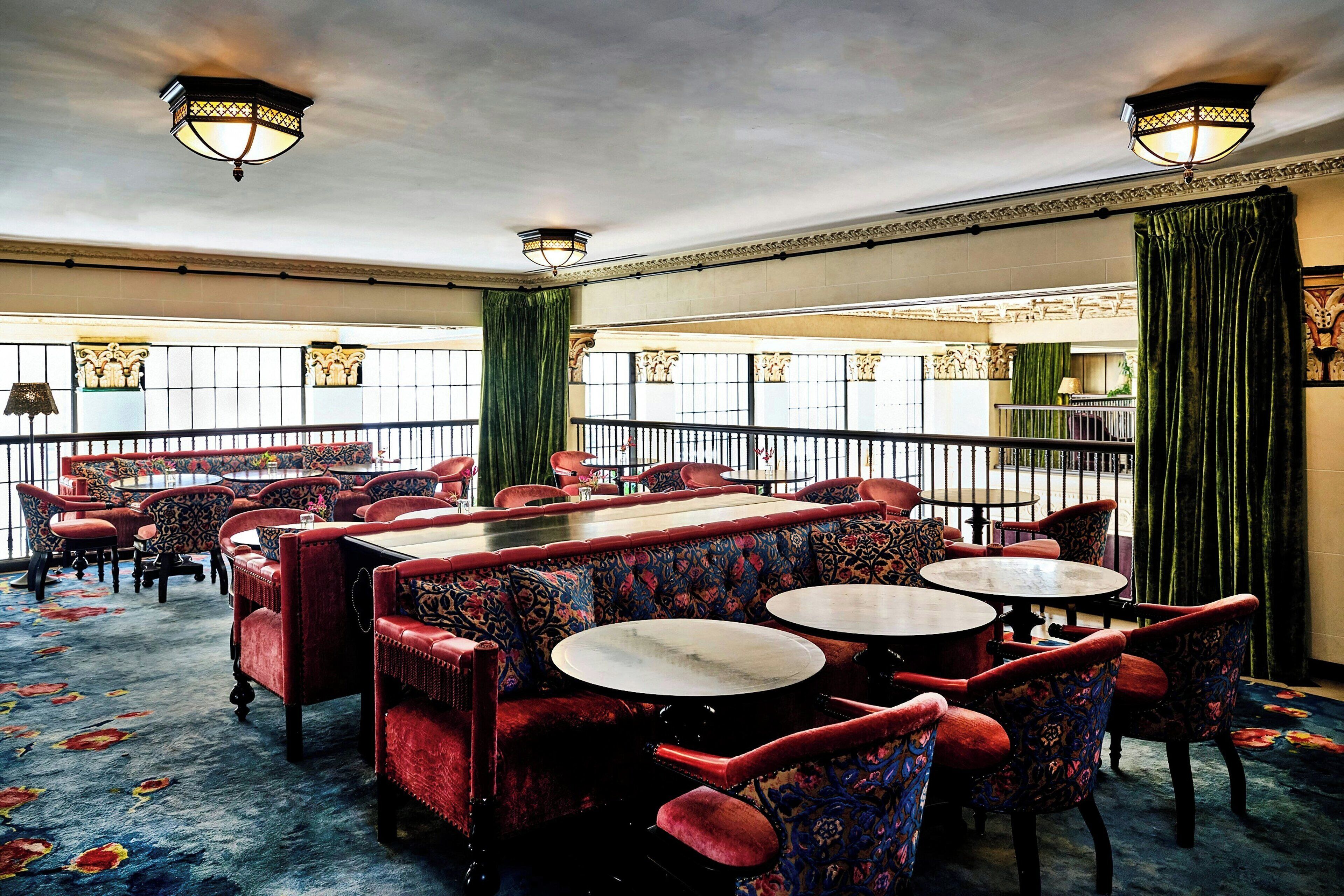 A spacious dining area with high ceilings, ornate ceiling lights, and a patterned carpet.