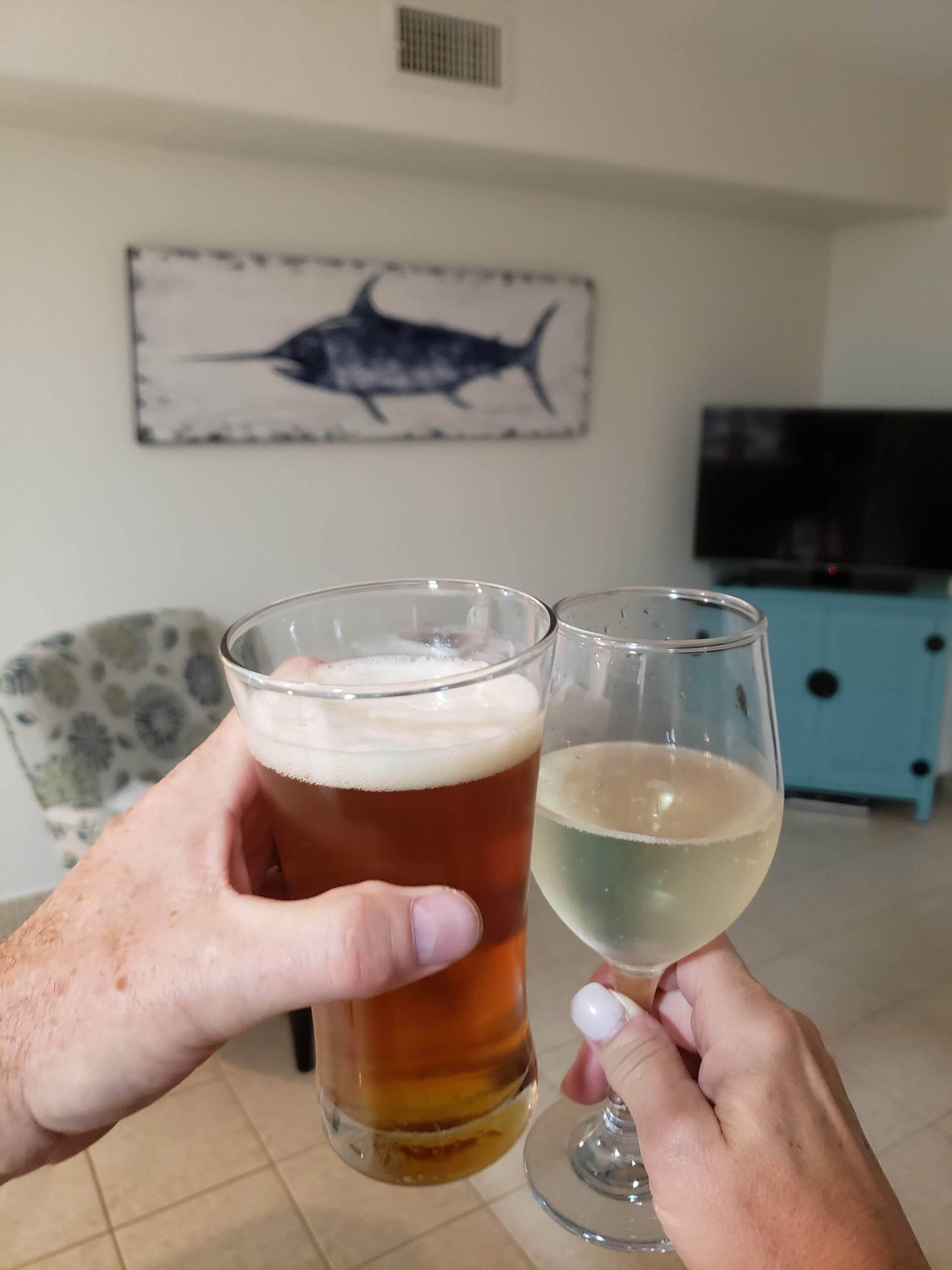 Two glasses of beer being held by a person.