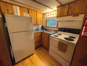 Enjoy cooking in this well-lit kitchen with a double oven, refrigerator, and sink.