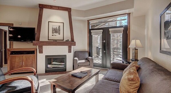 Cozy living room with a fireplace, TV, and comfortable seating area.