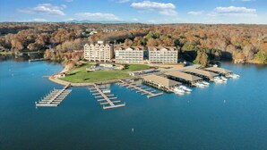 Un hotel junto al lago con varias construcciones, barcos amarrados y un puerto deportivo.