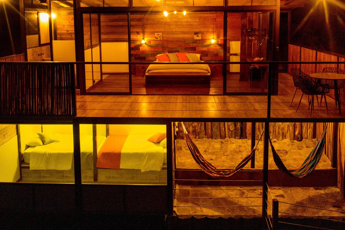 Ein modernes Hotelzimmer mit einem großen Bett, einem kleinen Tisch und einer Hängematte.