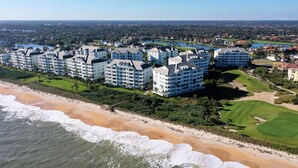 Un hôtel situé sur la côte, composé de plusieurs bâtiments, avec un accès direct à la plage et un parcours de golf.