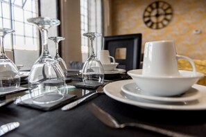 A dining table set with clear glassware, white plates, and a white bowl. - Sublime Stays Derby Millhouse, - 2 Bed Apartment (Derby)