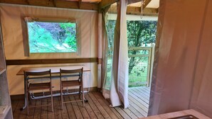 A wooden deck with a table and chairs, a window with a view of greenery, and a wooden bench. - Resort & Camping - Val De Braye (Besse-sur-Braye)