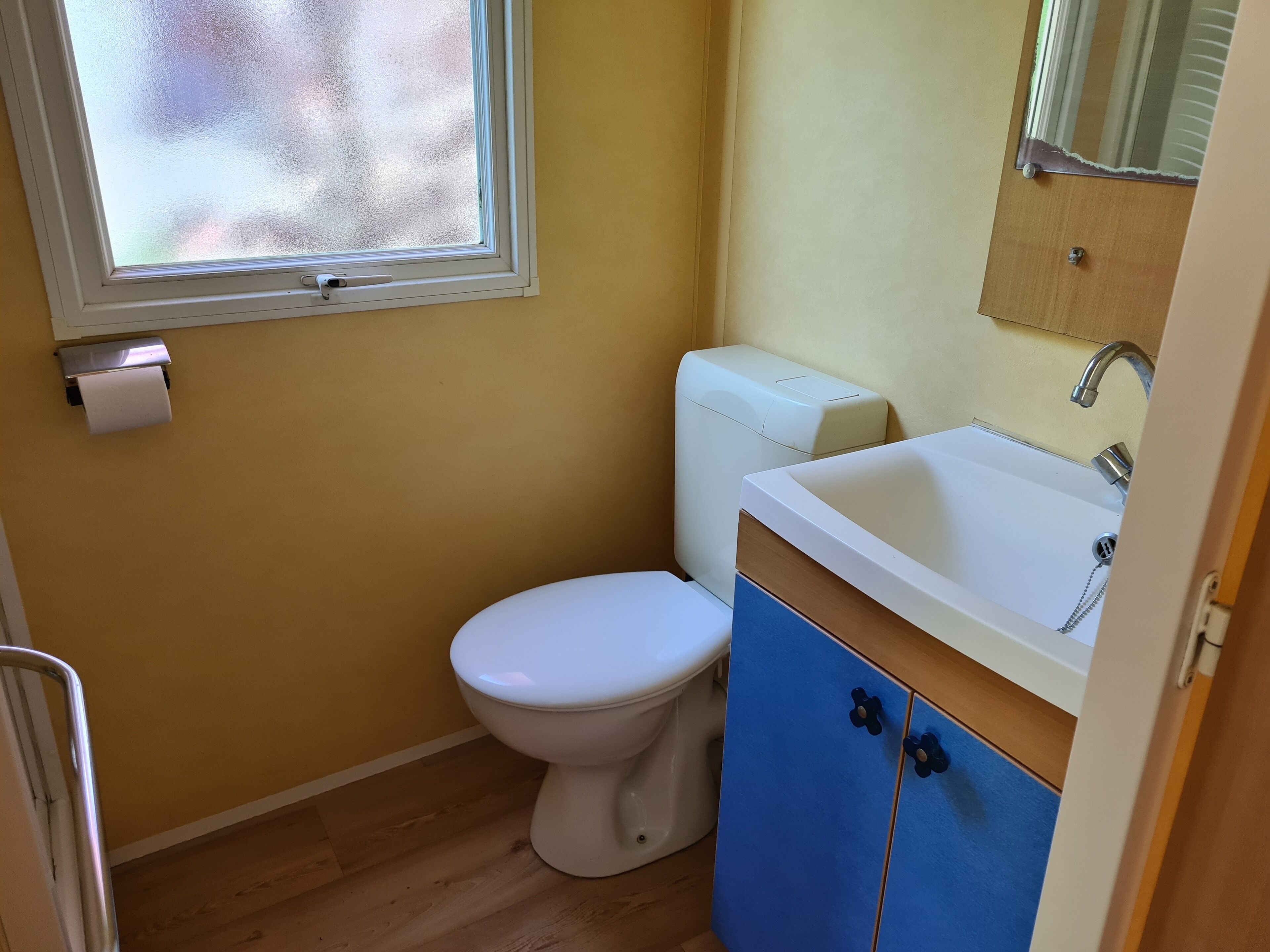 Un baño pequeño con inodoro, lavabo y ventana.