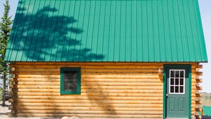 A log cabin with a green roof, a window, and a door. - Flagpole View Cabins - King Plus Cabin (Columbia Falls)