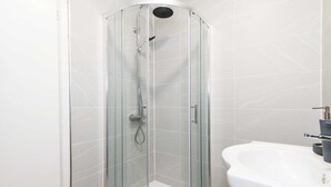 A glass-enclosed shower with a handheld showerhead and a handheld showerhead. - Michaelmas, Coventry - 2 Bed House Apartment (Coventry)