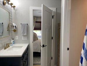 Une salle de bain avec un lavabo blanc, des robinetteries dorées et un miroir.