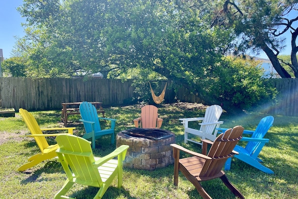 Backyard has firepit, Adirondack chairs, picnic table, tree swing, privacy fence