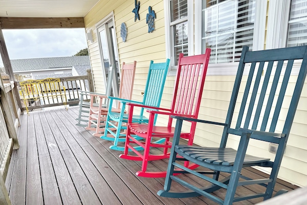 2nd level covered deck has colorful rockers and a bench to enjoy morning coffee