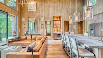 A modern interior with a wooden wall, a long dining table, and a sofa.