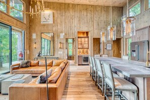 A modern interior with a wooden wall, a long dining table, and a sofa. - Greenridge - Hot tub & mountain views (Blue Ridge Mountains)