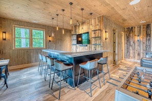 A wooden interior with a bar area, seating, and a foosball table. - Greenridge - Hot tub & mountain views (Blue Ridge Mountains)