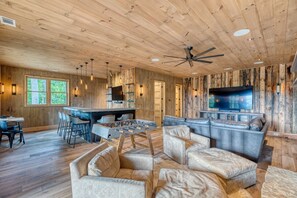 A spacious living area with a foosball table, a large TV, and a cozy seating arrangement. - Greenridge - Hot tub & mountain views (Blue Ridge Mountains)
