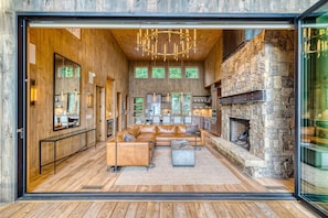 A modern interior with a stone fireplace, leather sofas, and a wooden floor. - Greenridge - Hot tub & mountain views (Blue Ridge Mountains)