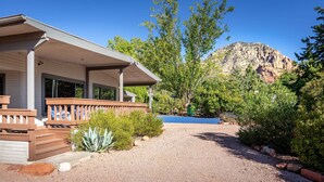 A house with a covered porch, a gravel driveway, and a mountain in the background. - Gorgeous Gem in West Sedona (Sedona)