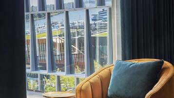 A modern room with a large window, a comfortable armchair, and a small round table.