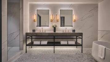 A modern bathroom with a marble vanity, dual sinks, and a large mirror.