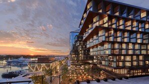 A modern building with multiple floors, large windows, and a waterfront view. - Pendry Washington DC - The Wharf (Washington)