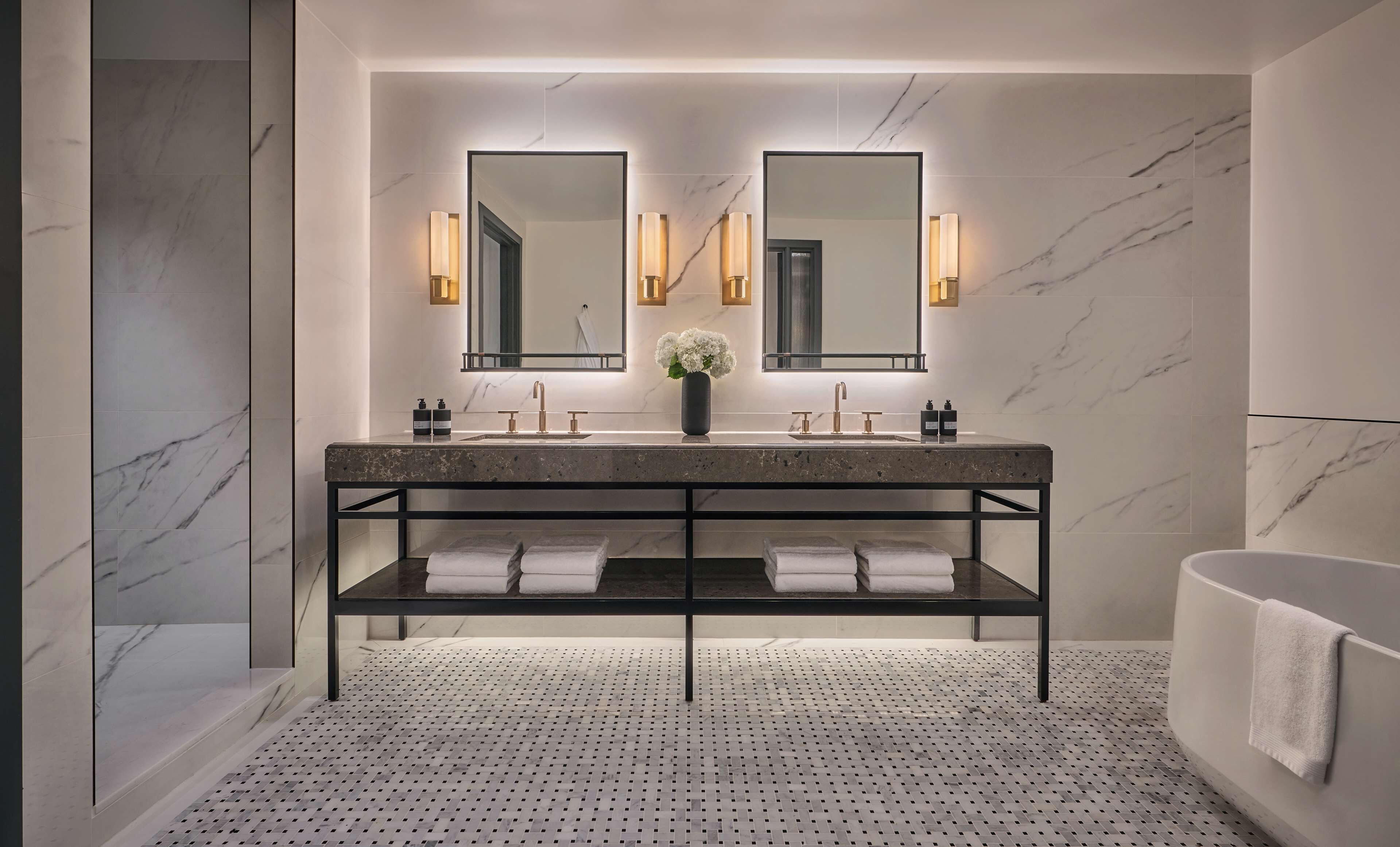 A modern bathroom with a marble vanity, dual sinks, and a large mirror.