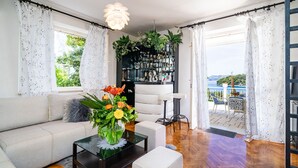Una sala de estar moderna con un sofá, una mesa de centro y vistas a un balcón con mobiliario exterior.