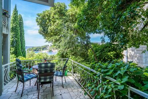 Enjoy the serene views of the water and surrounding landscape from this balcony, complete with comfortable wicker seating.