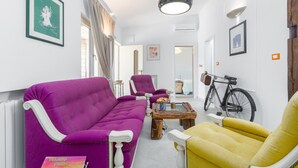 A living room with a purple sofa, a yellow armchair, and a wooden coffee table.