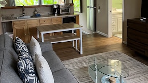 Eine moderne Küche mit Essbereich, Deckenventilator und Blick ins Freie.