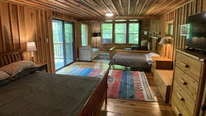 A cabin with two beds, a TV, and a large window. - Treetops Cabin in the Woods! (Bloomingdale)