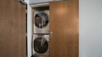 A compact laundry room with two stacked front-loading washing machines.
