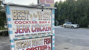 Wegwijzer voor een cocktailbar en restaurant met jerk chicken, met gegrilde kreeft en jerk saus.