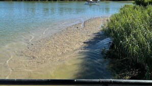 A riverbank with a boat and a clear sky. - Rougaroux Lodge @Venice Marina is a Sportsman dream! (Venice)