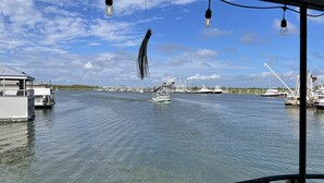 A marina with boats docked, a building on the left, and a clear sky. - Rougaroux Lodge @Venice Marina is a Sportsman dream! (Venice)