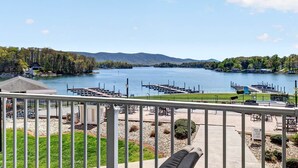 Blick auf einen See mit angestaubten Booten, einem Gazebo und einer Wiese mit Sitzgelegenheiten.