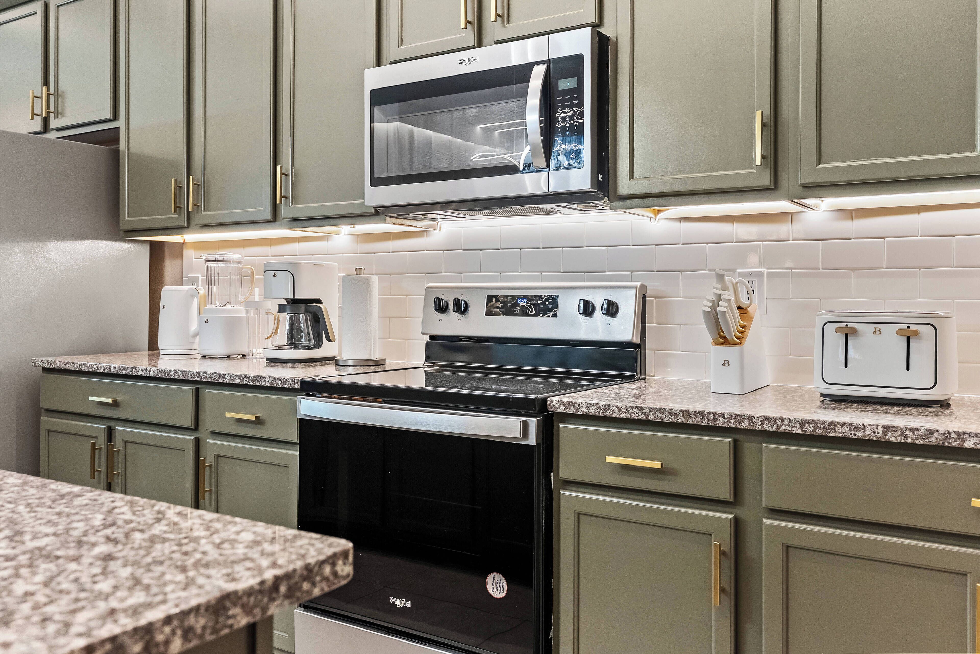 A modern kitchen with a built-in microwave, stove, and toaster.