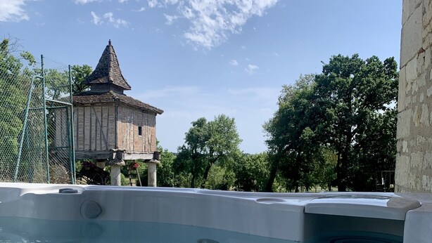Una piscina con un edificio de piedra al fondo.