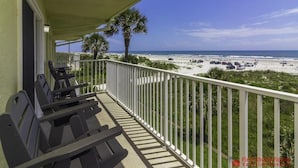 A balcony with outdoor furniture overlooking a beach and ocean. - Spectacular Direct Oceanfront Condo ~ Wraparound Balcony  ~ Top Floor! (Saint Augustine)
