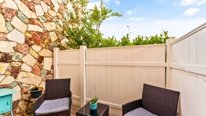A patio with wicker chairs, a small table, and a potted plant. - Cozy Studio - Mins to WeWork, Sony Pics & Venice with Parking (Culver City)