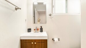 A bathroom with a wooden vanity, a white sink, a mirror, and a toilet. - Cozy Studio - Mins to WeWork, Sony Pics & Venice with Parking (Culver City)