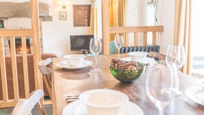 A dining table set with white bowls, wine glasses, and a green bowl with pinecones. - Bowmanstead Cottage - quirky & cosy traditional village cottage (Coniston)
