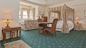 A room with a four-poster bed, a dining table with chairs, a sofa, and a chandelier. - Drawing Room, grand apartment with stunning lake views across Beatrix Potter country (Far Sawrey)