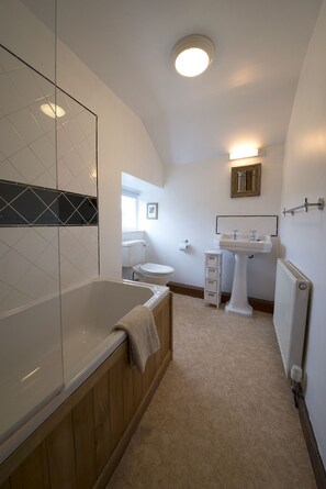 A modern bathroom with a freestanding bathtub, a toilet, and a sink. - Poppy Cottage, village cottage with lake views (Coniston)