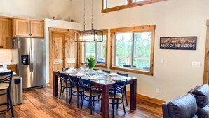Eine geräumige Küche mit Holzausstattung, einem Edelstahlkühlschrank und einem Essbereich mit Holztisch und Stühlen.